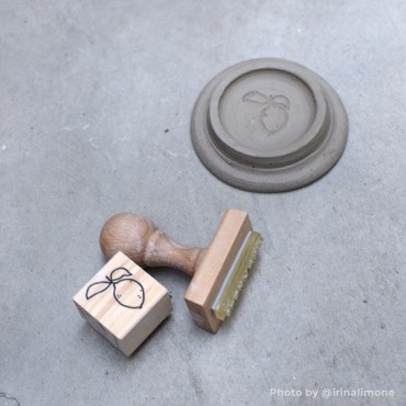 A custom stamp that creates a logo imprint on ceramic and clay surfaces for branding A custom stamp that creates a logo imprint on ceramic and clay surfaces for branding