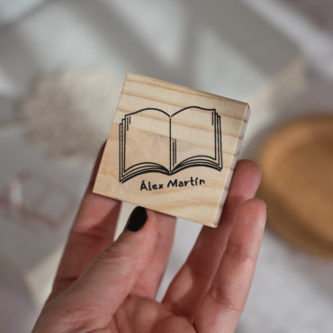 Personalized library stamp with an open book design and custom name.