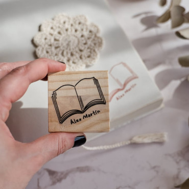 Custom bookplate stamp featuring a hand-drawn open book illustration.