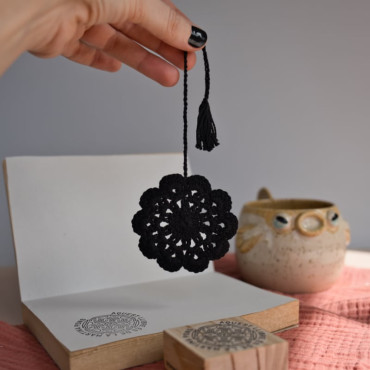 Handcrafted crochet bookmark in beige or black, featuring a flower design, perfect for readers.