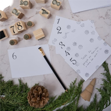 A workspace with craft supplies, featuring the postcards and envelopes ready for customization.