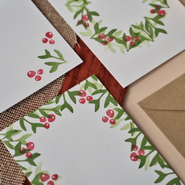 A close-up of a blank white postcard with a Kraft envelope partially tucked underneath.